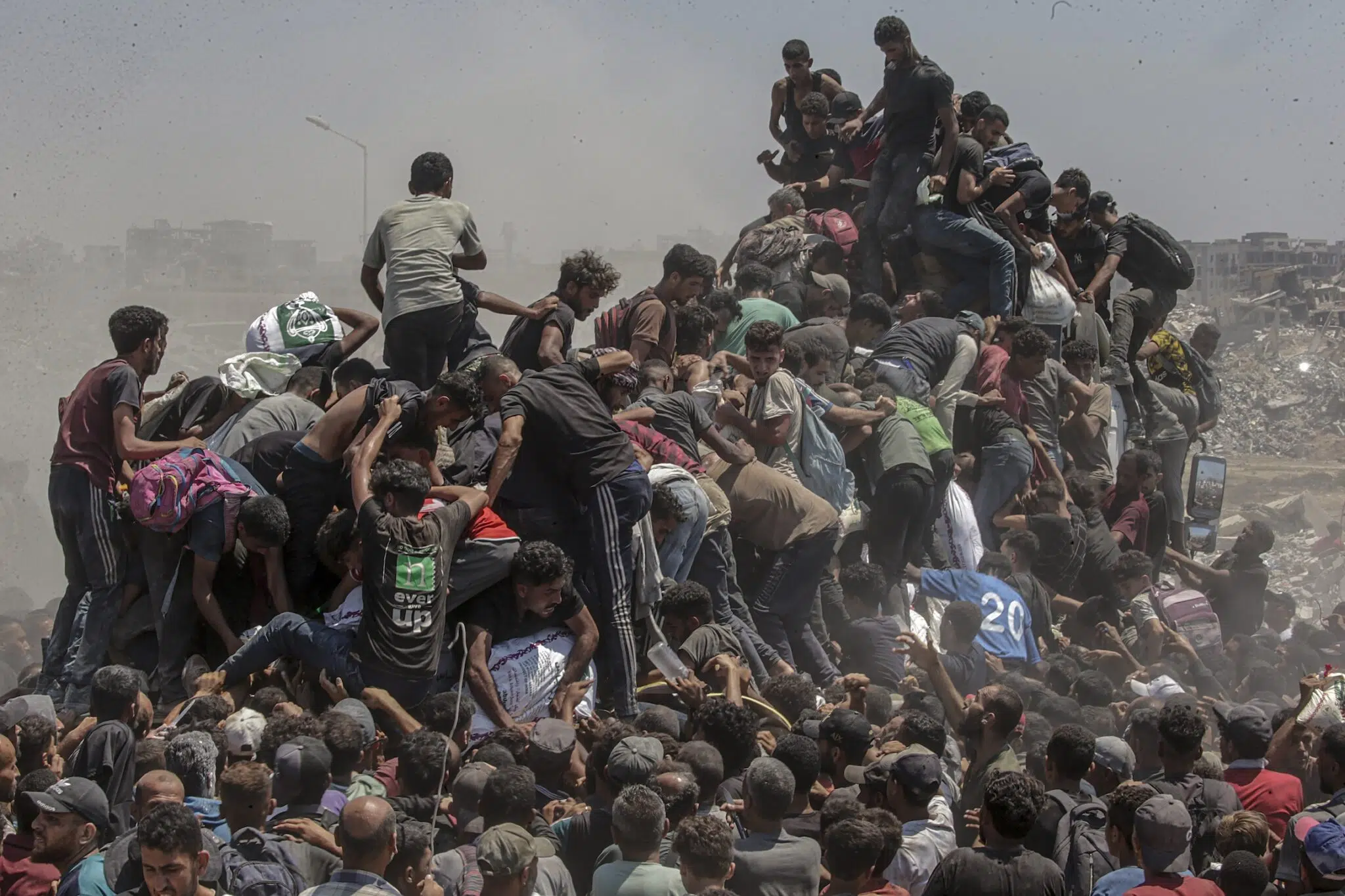 Saber Nuraldin, &ldquo;Aid Emergency in Gaza,&rdquo; for EPA Images. Palestinians climb onto an aid truck as it enters the Gaza Strip via the Zikim Crossing in an attempt to get flour, during what the Israeli military called a &ldquo;tactical suspension&rdquo; in operations to allow humanitarian aid through. July 27, 2025.