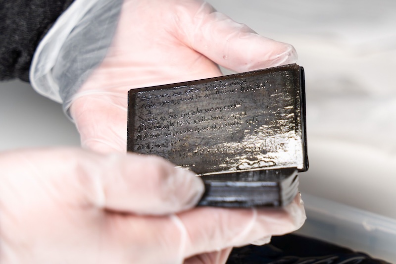 Medieval notebook found in an old latrine in Germany being inspected for restoration.