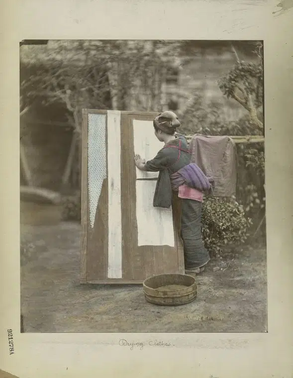 Hand-colored photograph of woman drying clothes in 19th-century Japan