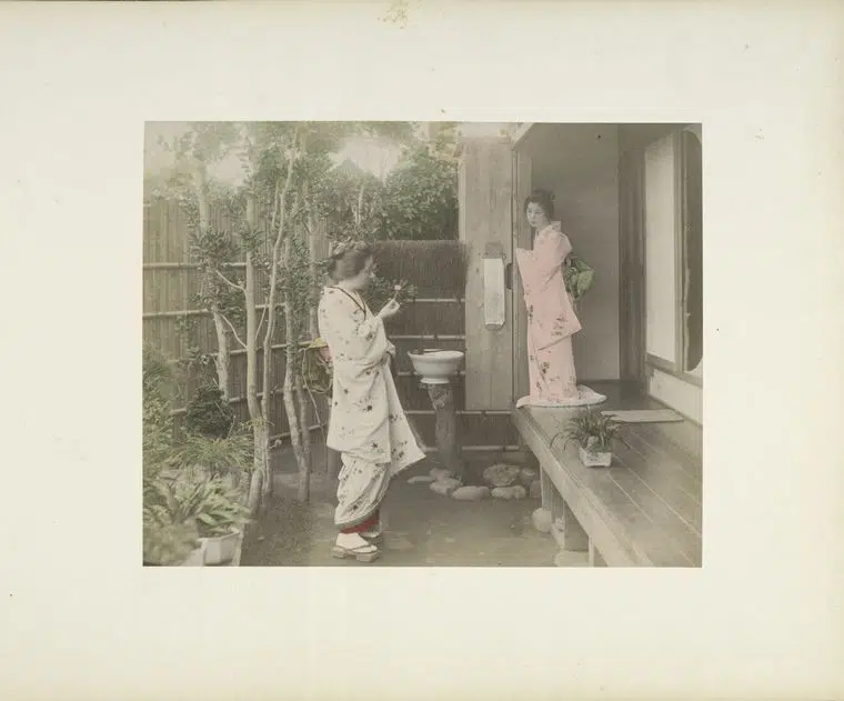 Hand-colored photograph of two girls talking in 19th-century Japan