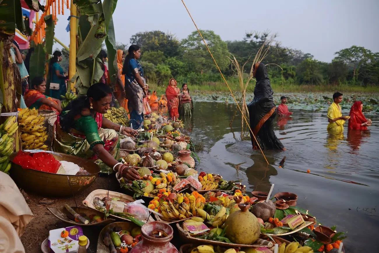 Food offered to sun god with people standing in a body of water