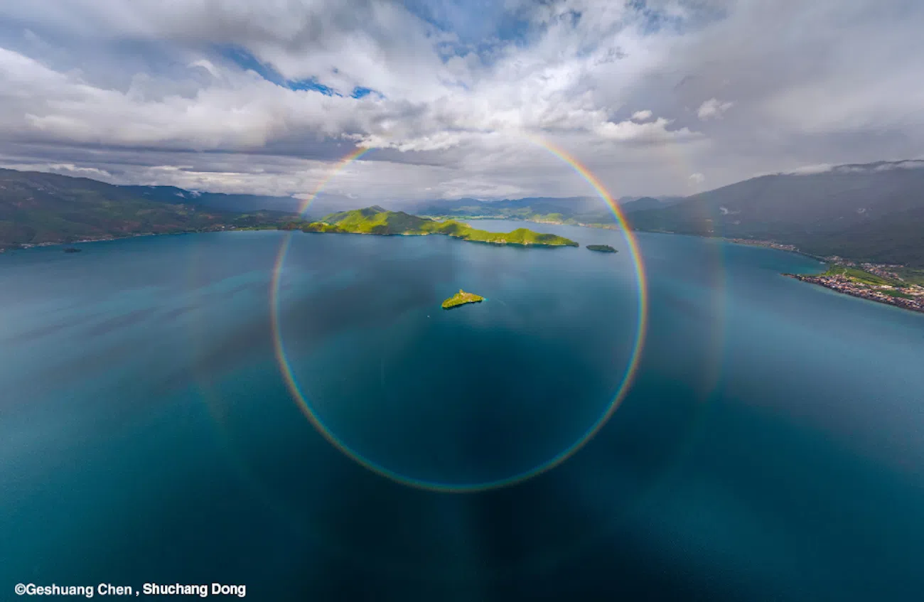 Circular rainbow around a boat in the ocean