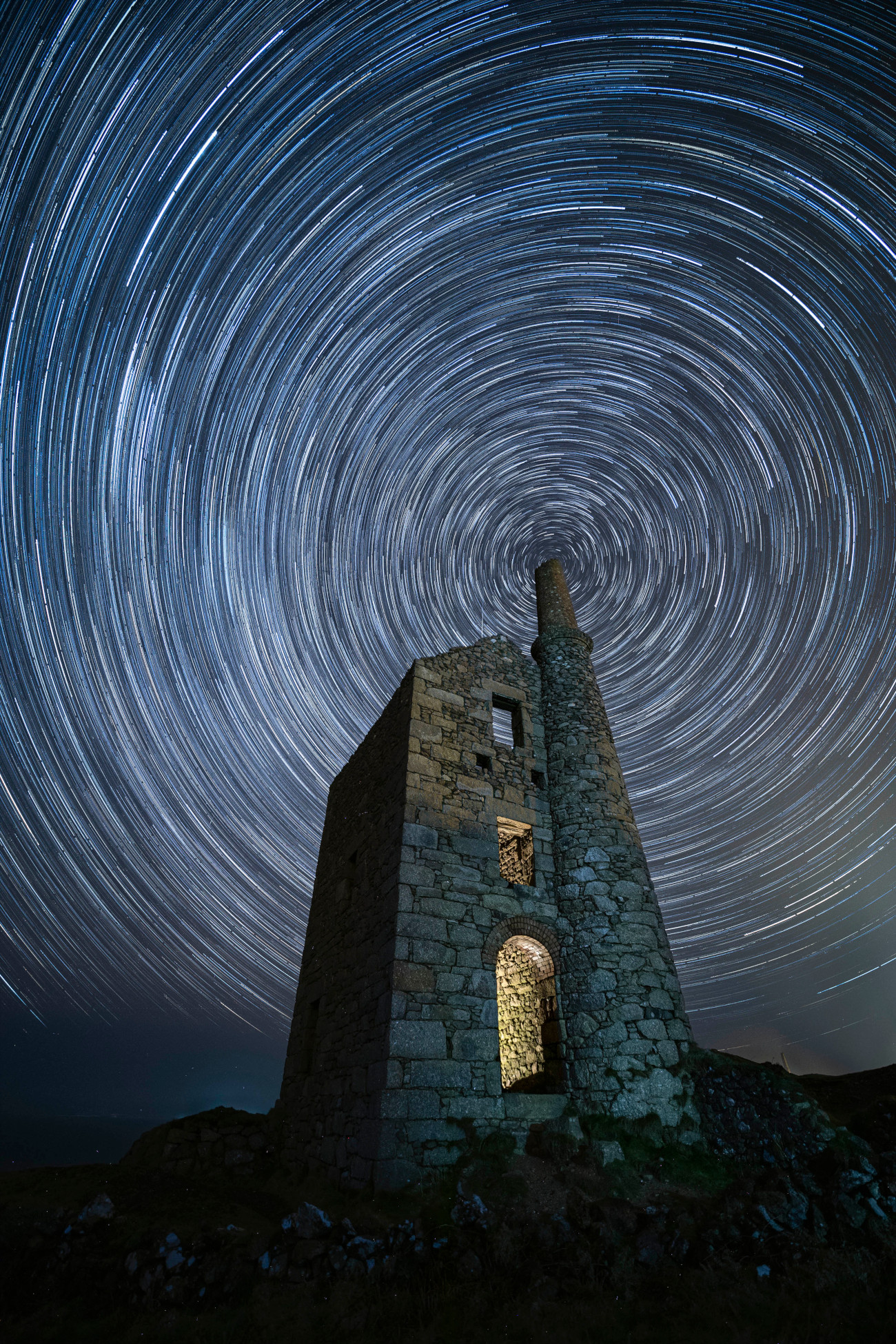 People & Space. "Vortex" © Jennifer Rogers (UK). This image of a star trail aligned with the chimney of the former tin mine Wheal Owles in Cornwall was taken on a cold night in February. Jennifer Rogers took time to position Polaris directly above the chimney in the composition. Taken with a Canon EOS 5D Mark IV camera, 14 mm f/2.8, ISO 1600, Foreground: 1 x 60-second exposure; Star trail: 72 x 60-second exposures. Location: West Wheal Owles, Cornwall, England, 22 February 2025