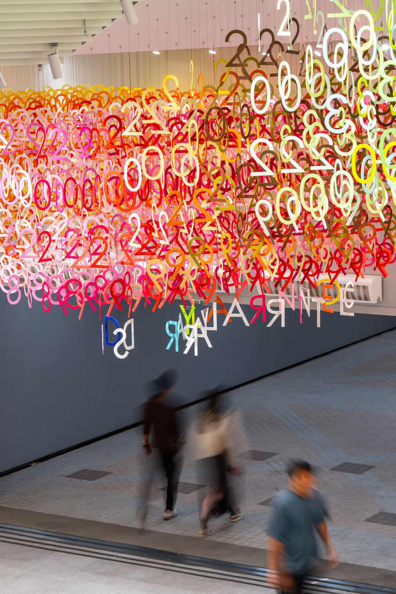 Colorful numerals hang in overlapping rows as part of Emmanuelle Moureaux's FLOW installation.