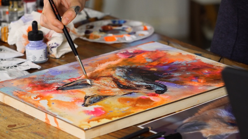 Artist Dimitra Milan Working on an Painting of a Fox on an Abstract Background