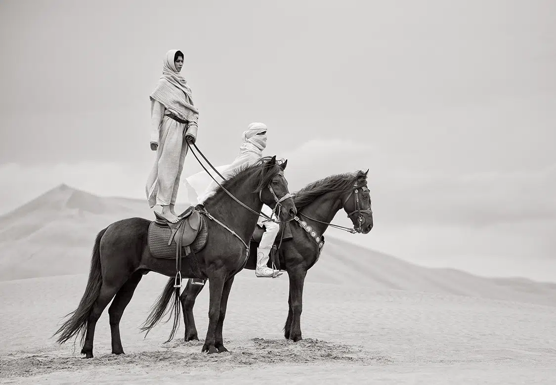 Photo of women on horses in the desert.