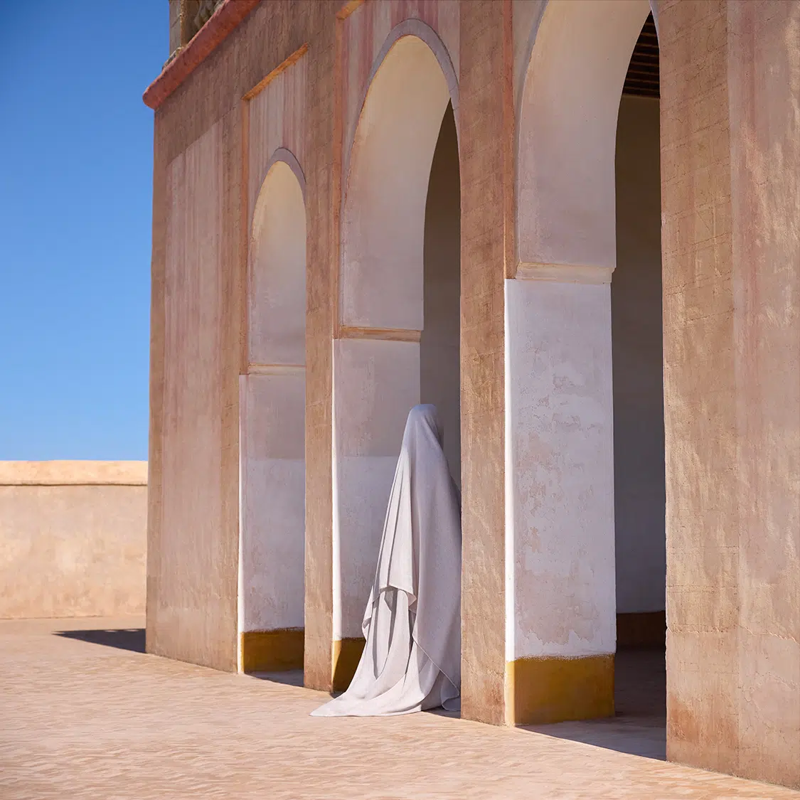 Photo of figure standing in doorway in the desert.