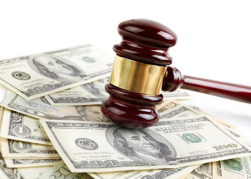 Auction gavel on a scattered pile of hundred dollar bills