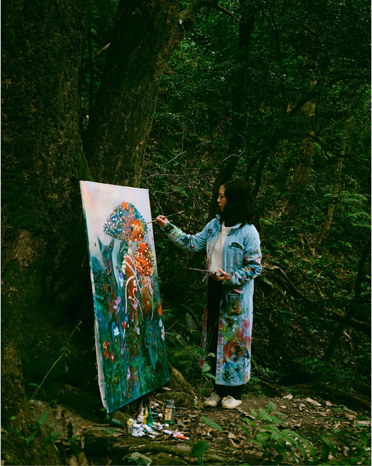 Photo of a woman painting in the forest. 