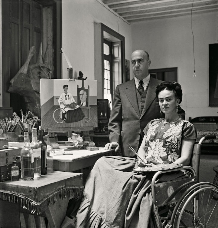 Frida Kahlo junto a uno de sus autorretratos en silla de ruedas